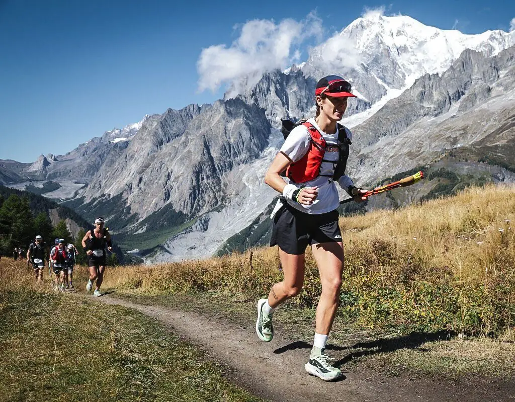 Anne Mjelva løper på sti i Alpene under CCC by UTMB, med Mont Blanc bak seg.